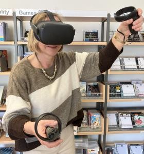 Frau trägt eine VR Brille und spielt ein Spiel damit