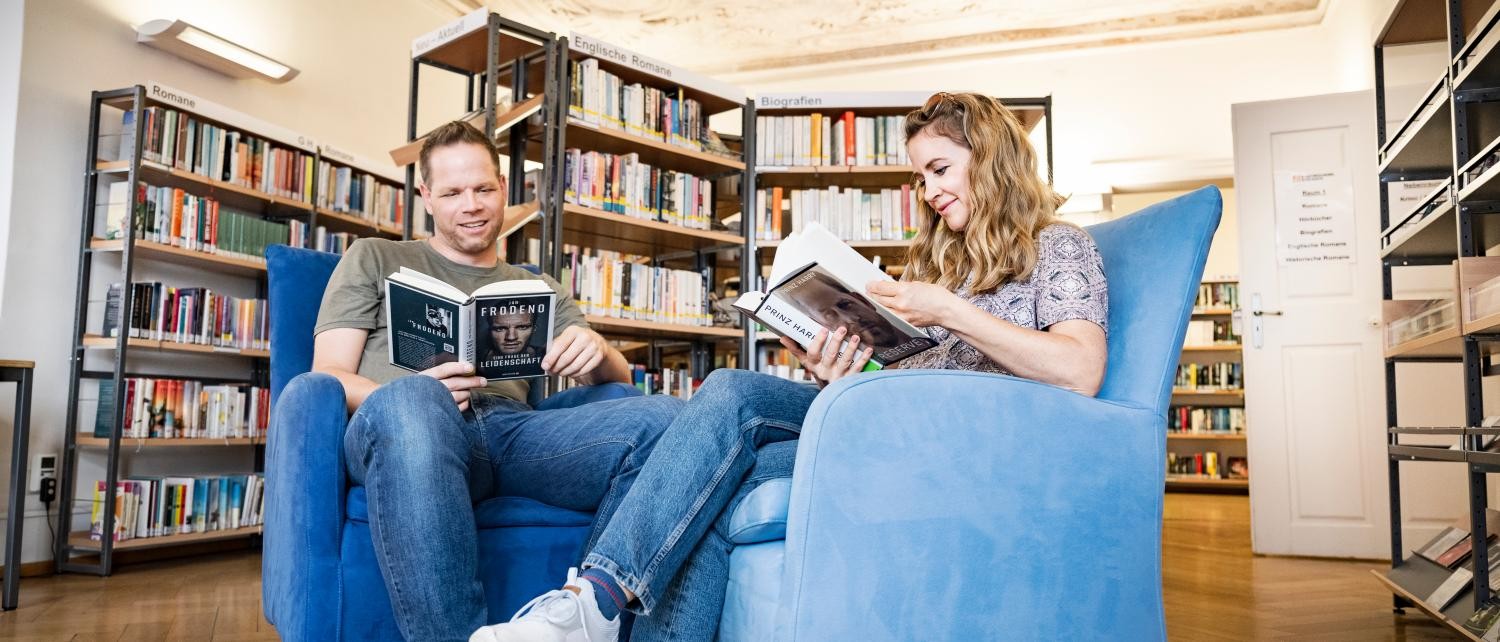 Ein Mann und eine Frau am Lesen in zwei Sesseln im Romanzimmer