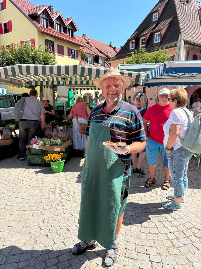 Mann mit seinem Wochenmarktstand Mann mit seinem Wochenmarktstand